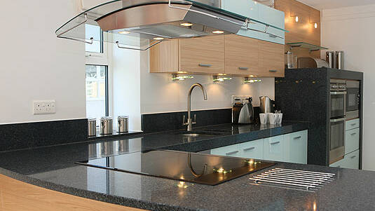 Moderne Küchenarbeitsplatte und Wandsockel aus schwarzem Granit Black Pearl.