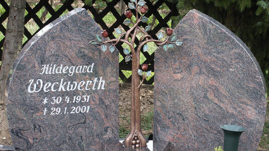Zweiteiliger Gedenkstein aus Granit mit Rosenbaum.