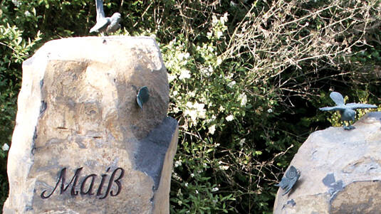 Grabschmuck am Stein: Schmetterlinge und Vögel.