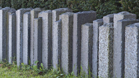 Palisade aus Granit in unterschiedlichen Farben und Proportionen.